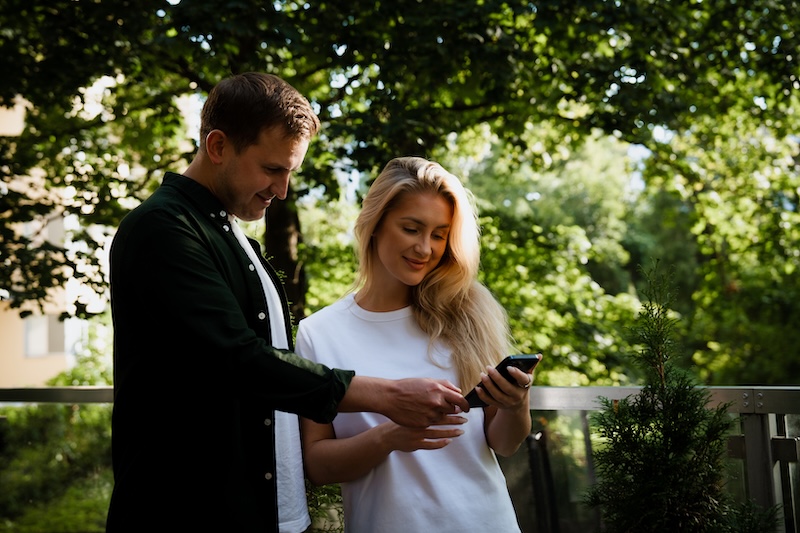 A pair of users reviewing payments on their phone.